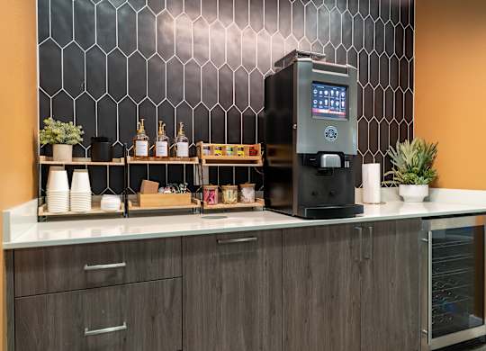 A modern coffee machine is on a counter with a digital display.