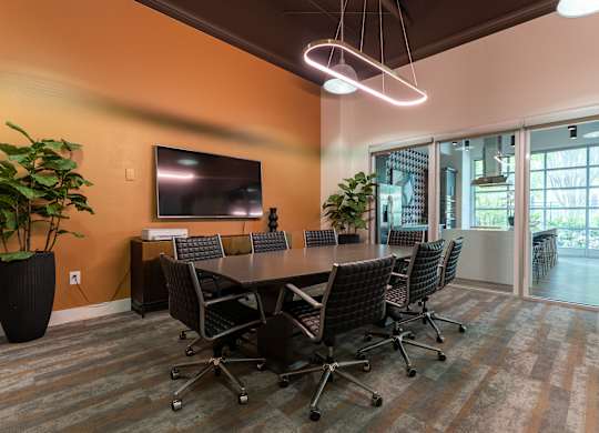 A conference room with a long table and chairs.