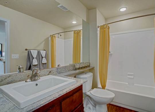 A bathroom with a sink, toilet, and bathtub.