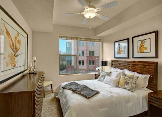 A bedroom with a large bed and a ceiling fan.