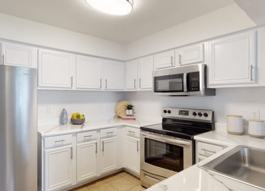 a kitchen with white cabinets and stainless steel appliances