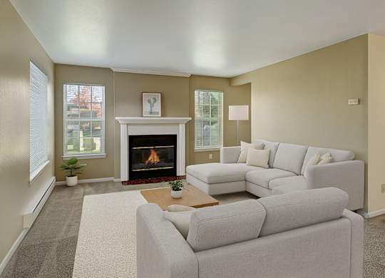 A living room with a fireplace and a grey couch.