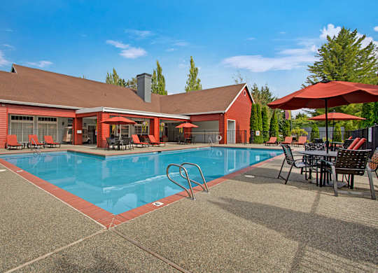 A red building with a pool in front.