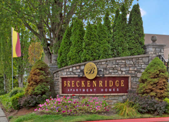 A sign for Breckenridge Apartment Homes is displayed in front of a landscaped area.