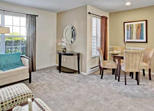A bedroom with a bed, chair, and a painting on the wall.