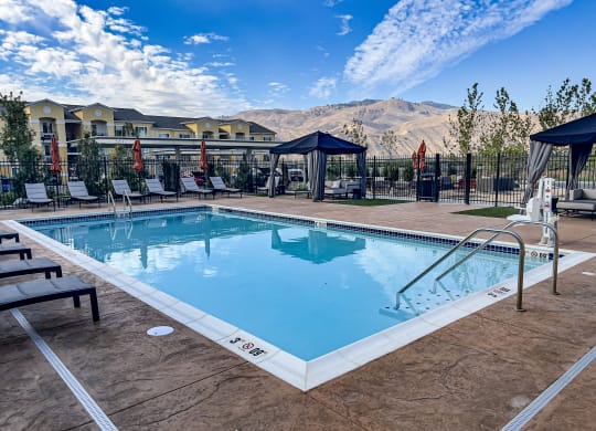 a resort style pool with lounge chairs and gazebos