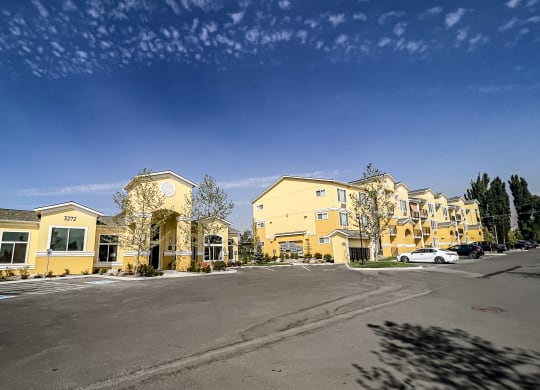a row of apartment buildings with a parking lot in front of them