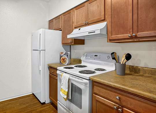 A white refrigerator sits next to a stove in a kitchen.