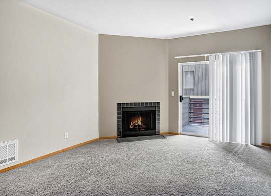 A living room with a fireplace and a carpeted floor.