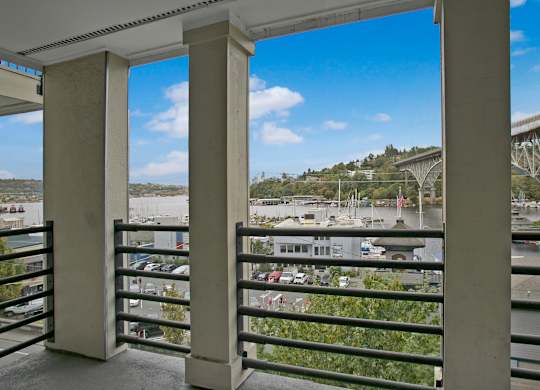 A balcony with a view of a parking lot and a bridge.