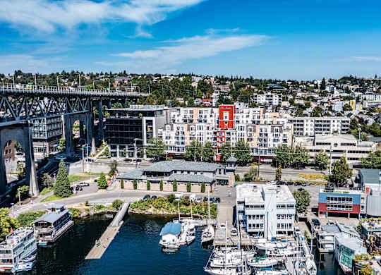 A cityscape with a bridge, buildings, and boats.