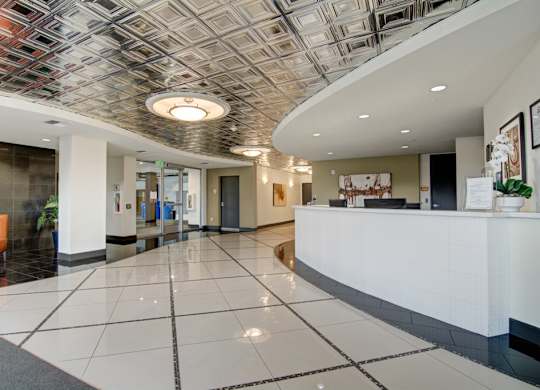 A reception area with a white reception desk and a tiled floor.