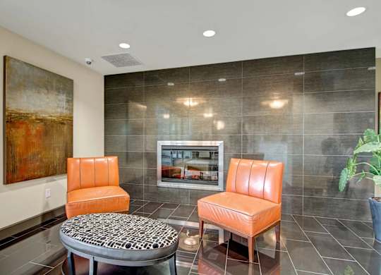 A living room with a grey and orange theme.