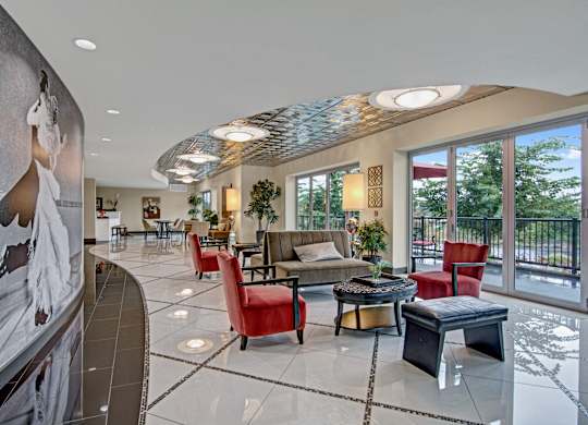 A modern living room with a glass table and red chairs.