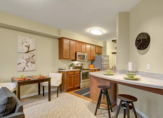 A kitchen with a table and chairs in front of it.