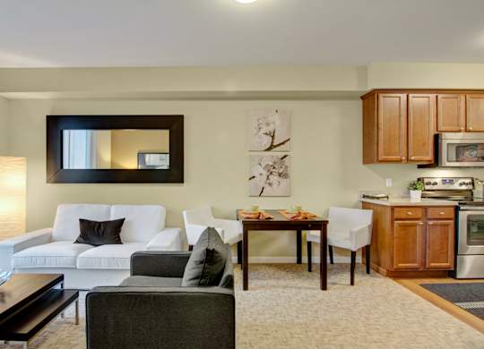 A modern living room with a white couch and a dining table.