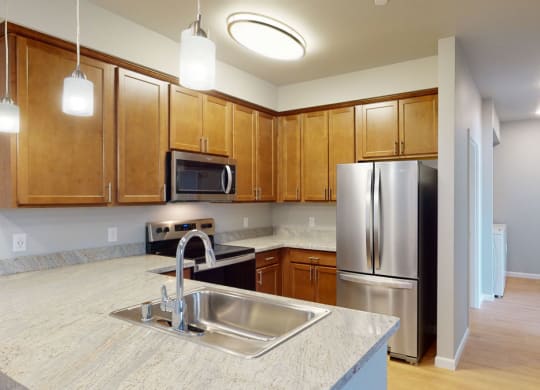 a kitchen with wooden cabinets and stainless steel appliances