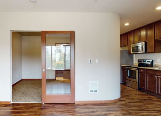 a kitchen and living room with wood floors and white walls