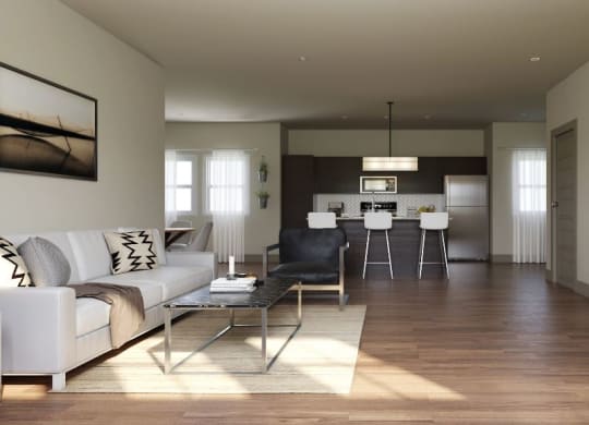 Modern open-concept living room here at 49 West Apartments with a white sofa, abstract art, and a sleek kitchen. Natural light fills the space, creating a cozy, inviting atmosphere.