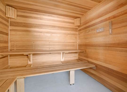 A relaxing sauna here at The Lafayette with warm wood paneling and tiered bench seating. A built-in thermometer and heater create a comfortable, spa-like space for unwinding.