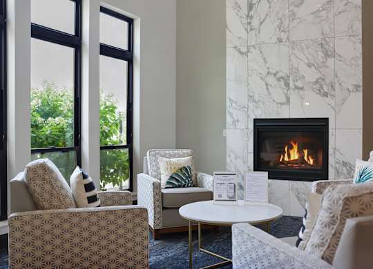 A living room with a fireplace and chairs.