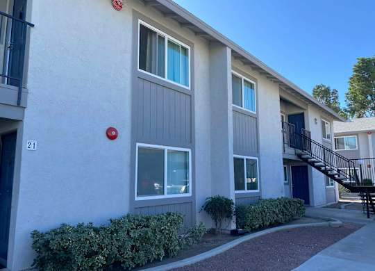 A building with a red fire alarm on the wall.