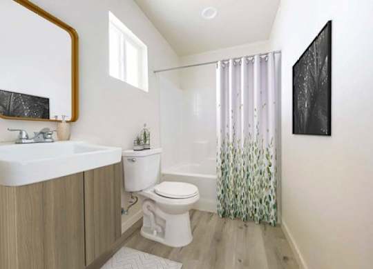 A bathroom with a toilet, sink, and shower.
