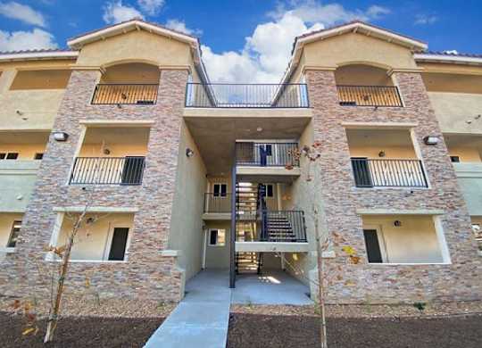 A multi-story apartment building with stone walls and balconies.