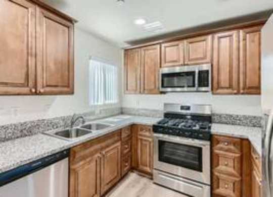 A kitchen with wooden cabinets and a granite countertop.