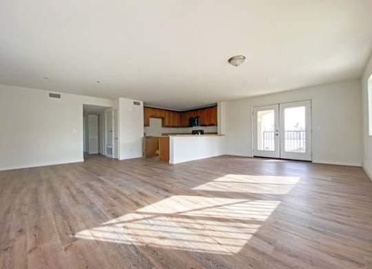 A large empty room with wooden floors and white walls.