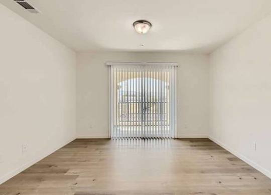 A room with a sliding door and wooden floor.