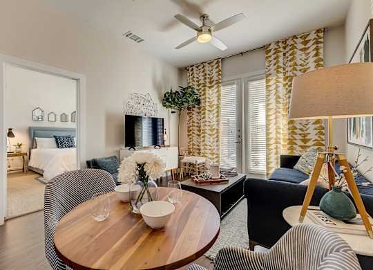 A living room with a wooden table and striped chairs.