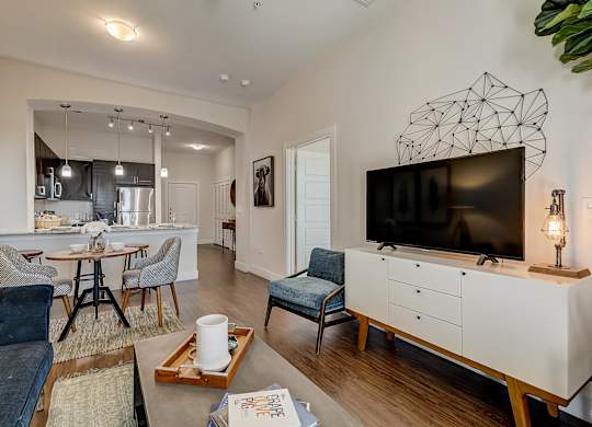 A living room with a blue couch and a white cabinet with a television on top.