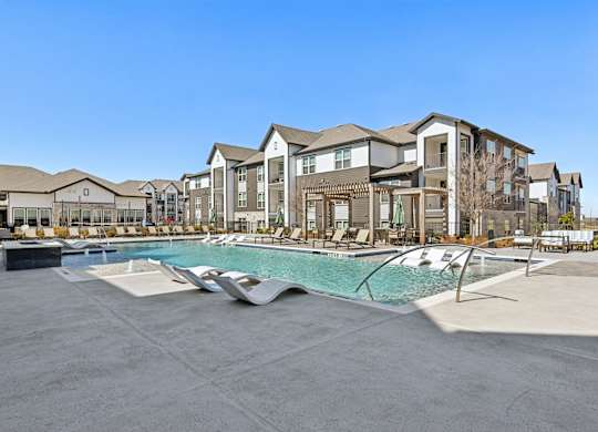 A large swimming pool in front of apartment buildings.
