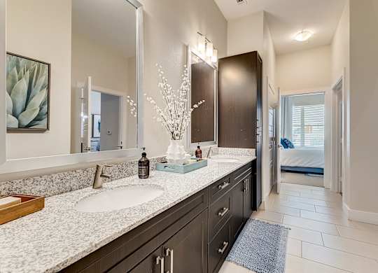A bathroom with a large mirror above a double sink vanity.