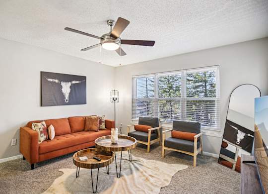 A living room with a couch, chairs, and a coffee table.