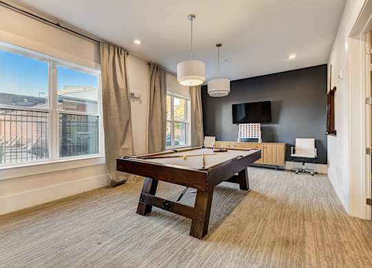 A room with a pool table and a chair.