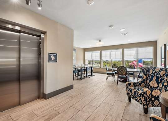 A room with a wooden floor and a glass wall with a view of the outside.