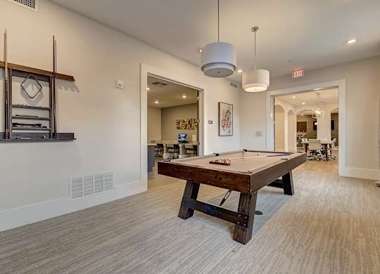 A room with a pool table and a mirror on the wall.