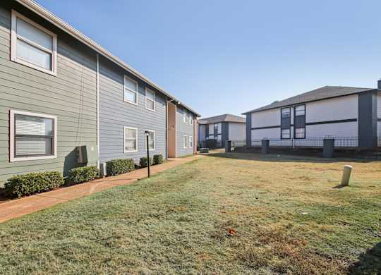 A row of houses with green lawns in front.