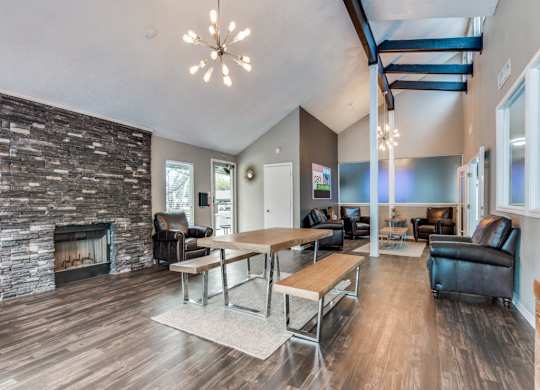 A modern living room with a stone fireplace and wooden floors.