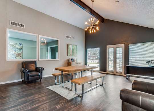A living room with a black leather chair and a wooden table.