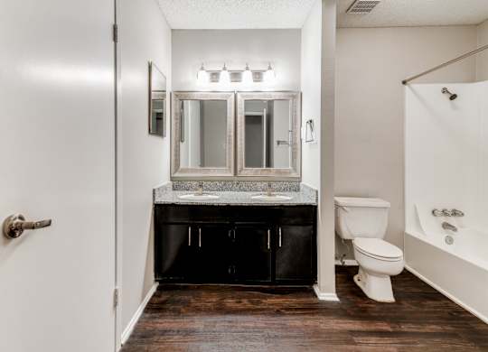 A bathroom with a white toilet and a white bathtub.