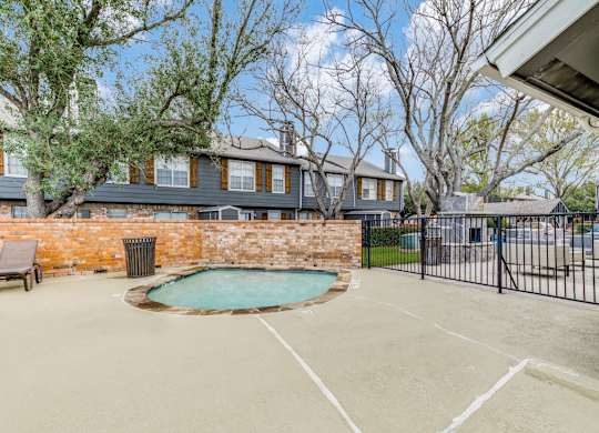 A backyard with a pool and a fence.