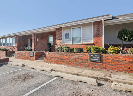 A brick building with a sign that says "Future Parent Parking" in front of it.