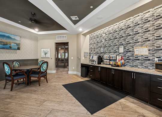 A stone wall with a counter and chairs in front of it.