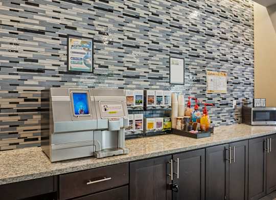 A kitchen with a stone wall and a microwave on the counter.