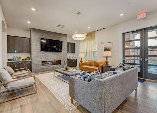 A modern living room with a grey couch, a fireplace, and a flat screen TV.