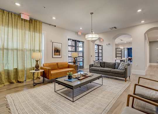 A living room with a glass coffee table in the middle.