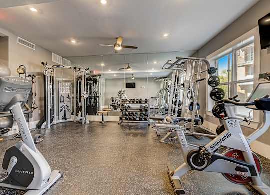 A gym with a variety of equipment including a spinning bike.